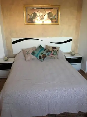 a bedroom with a large bed with two night stands at Casa Pescadores de Vallterra in El Palmar