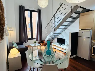 a living room with a glass table and a staircase at Petit Palomar - PalomarGroup in Valencia