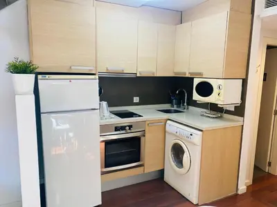 a kitchen with a white refrigerator and a dishwasher at Petit Palomar - PalomarGroup in Valencia