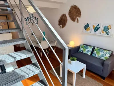 a living room with a staircase with a couch and a table at Petit Palomar - PalomarGroup in Valencia