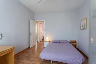 a white bedroom with a bed and a wooden floor at Apartment City of Arts and Sciences 2 in Valencia