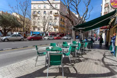 a row of green tables and chairs on a city street at Apartment City of Arts and Sciences 2 in Valencia
