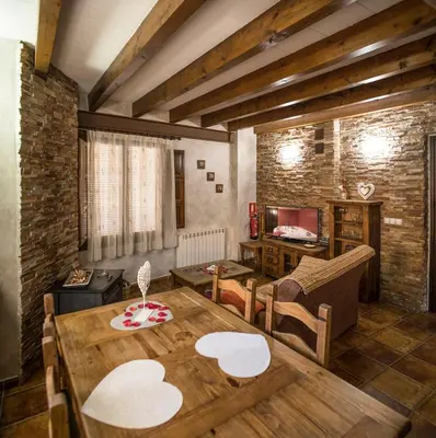 a living room with a wooden table and chairs at Cases Rurals El Castell in Torres-Torres