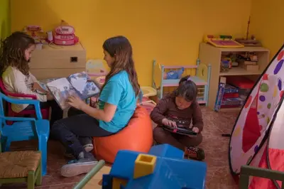 three girls sitting on an orange ball in a room at Cases Rurals El Castell in Torres-Torres