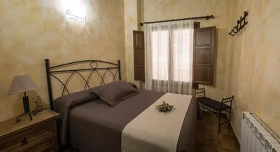 a bedroom with a bed and a window and a chair at Cases Rurals El Castell in Torres-Torres