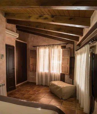 a bathroom with a tub and a window with curtains at Cases Rurals El Castell in Torres-Torres