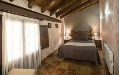 a bedroom with a large bed and a window at Cases Rurals El Castell in Torres-Torres