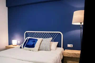 a bedroom with two beds and a blue wall at B&B El Mercat in Valencia