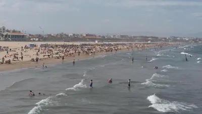 a group of people in the water at a beach at APARTMENTSUITESPAIN Beach Economy in Valencia