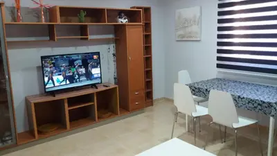 a living room with a television and a table and chairs at APARTMENTSUITESPAIN Beach Economy in Valencia
