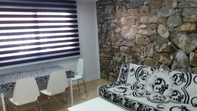a room with a stone wall and a couch and chairs at APARTMENTSUITESPAIN Beach Economy in Valencia