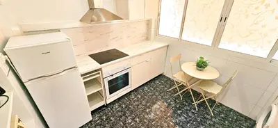 a table and chairs in a room with white walls at Your home in Valencia in Valencia