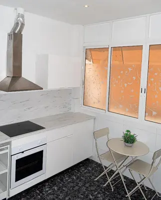 a white kitchen with a stove top oven next to a refrigerator at Your home in Valencia in Valencia