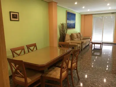 a dining room with a table and chairs and a couch at Apartament Magnífico in Paiporta