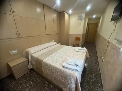 a small bedroom with a bed and a chair at Apartament Magnífico in Paiporta