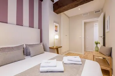 a bedroom with a large white bed with two towels at TTdSSa VLC Ramellets Street Central Market in Valencia