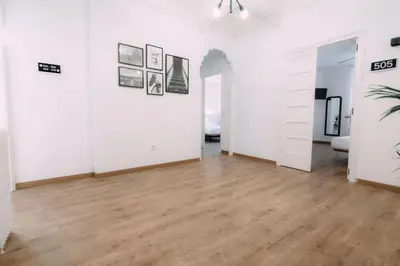 an empty living room with white walls and wooden floors at Concept Rooms in Valencia