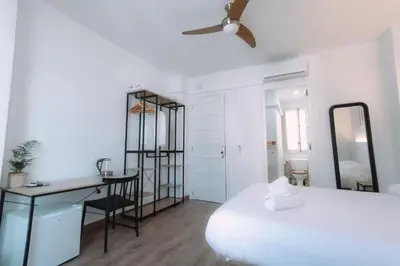 a bedroom with a bed and a desk and a mirror at Concept Rooms in Valencia