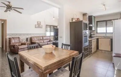 a kitchen and dining room with a wooden table and chairs at Nice Home In Alberique in Alberique
