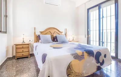 a bedroom with a large bed with a large window at Nice Home In Alberique in Alberique