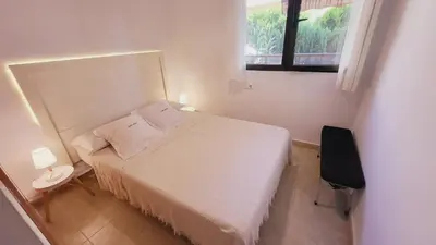 a small bedroom with a white bed and a window at Casa Dora Puzol playa in Puzol