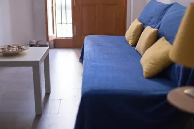 a blue bed with yellow pillows and a table at Cozy fisherman's house in Valencia
