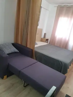 a room with two beds and a couch and a window at Versus Apartments near City of Arts in Valencia