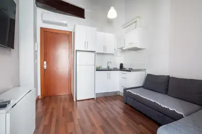 a living room with a couch and a kitchen at Up Town in Valencia