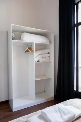 a white closet with white towels and a bed at Up Town in Valencia