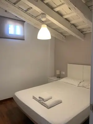 a bedroom with a white bed with two towels on it at Up Town in Valencia