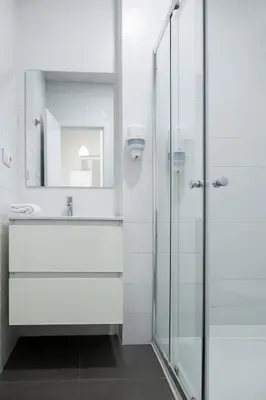 a bathroom with a glass shower and a sink at Up Town in Valencia