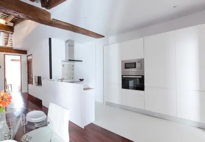 a white kitchen with white appliances and a wooden ceiling at Apartments Downtown Valencia in Valencia