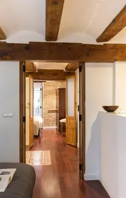 a living room with wooden ceilings and a room with a bed at Apartments Downtown Valencia in Valencia