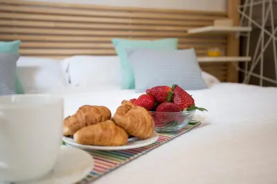 a plate of strawberries and croissants on a bed at Apartment Collado in Valencia