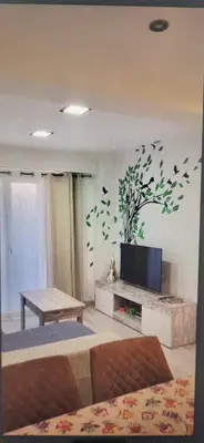 a living room with a tv on a wall with a plant mural at Apartamento Jardín de Ayora in Valencia