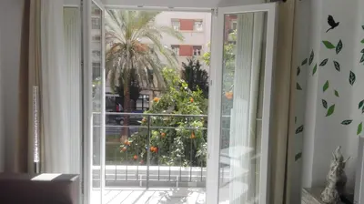 an open window with a view of a palm tree at Apartamento Jardín de Ayora in Valencia