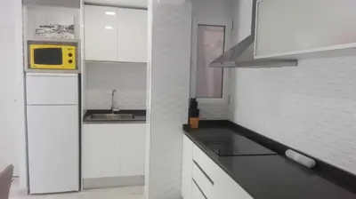 a kitchen with white cabinets and a yellow microwave at Apartamento Jardín de Ayora in Valencia