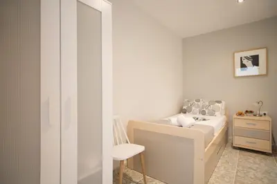 a small bedroom with a bed and a chair at SingularStays El Faro in Puzol