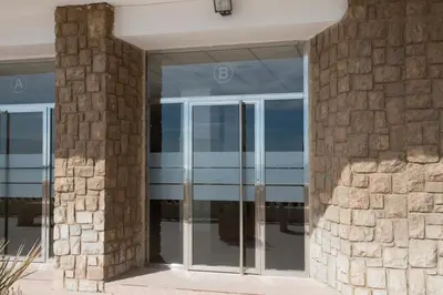 a glass door of a building with a stone wall at SingularStays El Faro in Puzol