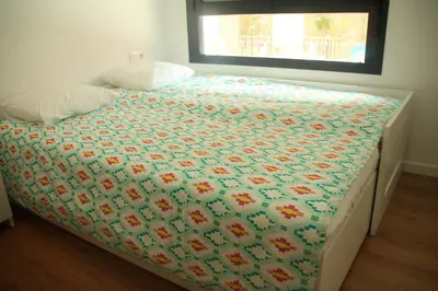 a bed in a bedroom with a floral bedspread at Apartamento Ribes Valencia in Valencia