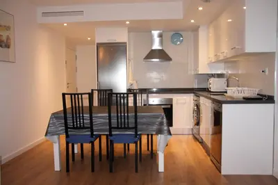 a kitchen with a black table and chairs in a kitchen at Apartamento Ribes Valencia in Valencia