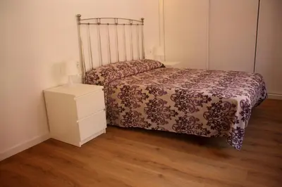 a small bedroom with a bed and a night stand at Apartamento Ribes Valencia in Valencia