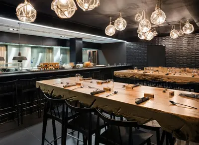 a restaurant with wooden tables and chairs and lights at One Shot Mercat in Valencia