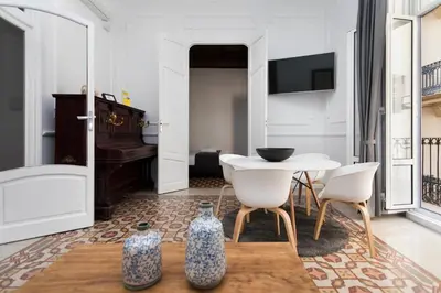 a living room with a table and chairs and a piano at Total Valencia Vintage in Valencia