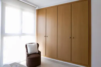 a room with wooden cabinets and a chair at ApartUP Patacona Horizon in Valencia