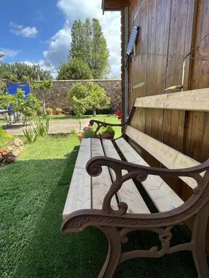 a wooden bench sitting in the grass next to a building at El Secanet in Algimia de Alfara