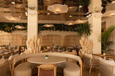 a restaurant with tables and chairs and potted plants at Hotel Miramar Valencia in Valencia