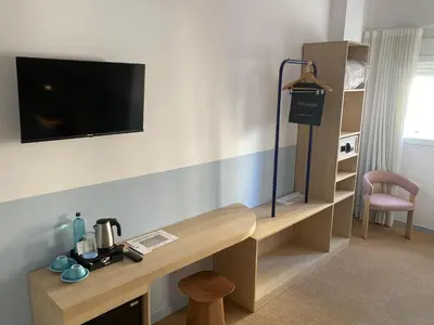 a room with a desk with a tv on the wall at Hotel Miramar Valencia in Valencia