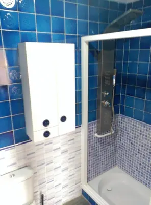 a blue tiled bathroom with a shower and a toilet at Malvarosa Beach Family in Valencia