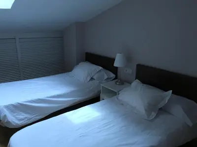 two beds in a hotel room with white sheets at Atico En El Centro in Valencia
